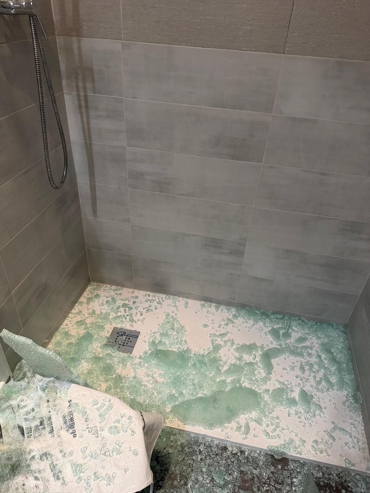 Instalación de ducha con baldosas modernas y suelo en construcción en un espacio de baño.